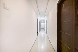 a long hallway with white walls and a door at Collection O Chidambaram Stadium Formerly Hotel Admire Suit in Chennai +33 photos