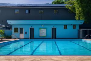 a swimming pool in front of a blue building at Juba Landmark Hotel in Juba