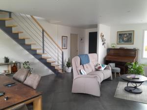 a living room with two chairs and a piano at Au château d'eau in Quintin