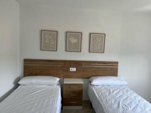 two beds sitting next to each other in a bedroom at Apartamentos Vive Laxe in Laxe