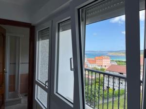 a room with two sliding glass doors and a balcony at Apartamentos Vive Laxe in Laxe