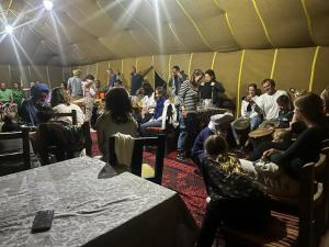 a group of people sitting in a tent at Sahara Standard Camp in Merzouga