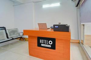a hotel reception desk with a laptop on top of it at Super Hotel O Erode Bus Stand in Erode
