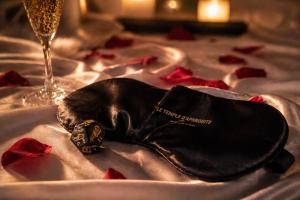 a black shoe sitting on a table with a glass of wine at Le temple d'Aphrodite, Appartement avec SPA in Vienne