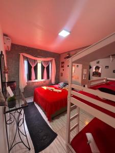 a bedroom with two bunk beds and a red bed at Suíte Harry Potter - Pousada Castelo do Luar in Penha +40 photos