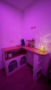 a purple room with a table in a room with a purple light at Luana SPA Boussois in Boussois