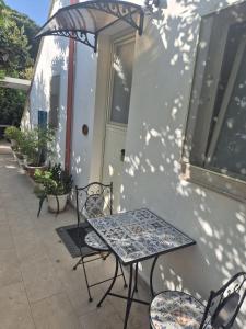 a patio with a table and chairs in front of a building at Drin room in Catanzaro Lido +10 photos
