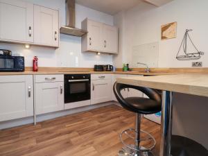 a kitchen with white cabinets and a black dishwasher at Flat 2, Dorstan in Carnforth