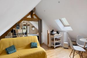a living room with a yellow couch and a table at La Lizardiere des Landes in La Flèche