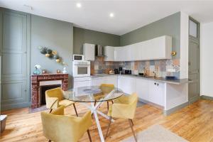 a kitchen with a glass table and yellow chairs at Trois Clés Apartment 2 - 2 bed in Eymet