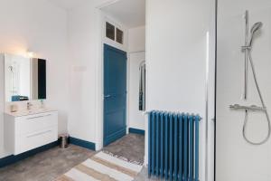 a bathroom with a blue door and a sink at Trois Clés Apartment 2 - 2 bed in Eymet