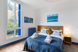 a bedroom with a blue and white bed with a window at Trois Clés Apartment 2 - 2 bed in Eymet