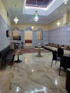 a lobby with couches and tables and stained glass windows at Ryad dar midelt in Midelt