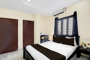 a bedroom with a black and white bed and a window at Super Collection O Kothapet Near Omini Hospital in Upal