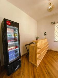 a cocacola refrigerator in a room with a table at Garibaldi Hostel & Pub in Curitiba