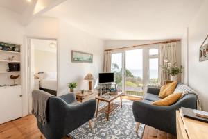 a living room with a couch and chairs and a television at 2 Bed in Stoke Fleming oc-bc777 in Stoke Fleming