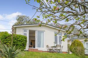 a white house with a table and chairs at 2 Bed in Stoke Fleming oc-bc777 in Stoke Fleming