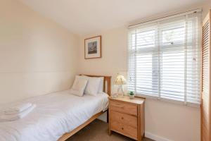 a bedroom with a bed and a dresser and a window at 2 Bed in Stoke Fleming oc-bc777 in Stoke Fleming