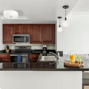 a kitchen with wooden cabinets and a stainless steel sink at Saint Thomas Villa with Ocean view in Frenchmans Reef Heliport +4 photos