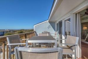 a patio with a table and chairs on a balcony at Sea-Nic View by Oak Island Accommodations in Caswell Beach