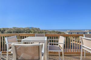 a patio with a table and chairs on a deck at Sea-Nic View by Oak Island Accommodations in Caswell Beach