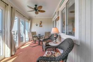 a screened in porch with chairs and a table at Sea-Nic View by Oak Island Accommodations in Caswell Beach