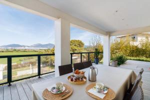 a dining room with a table and chairs on a porch with a view at Stagnolo in Porticcio