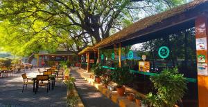 a restaurant with tables and chairs and plants in front of it at Juba Landmark Hotel in Juba