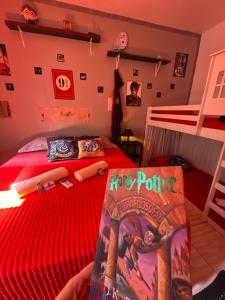 a bedroom with two bunk beds and a red bedspread at Suíte Harry Potter - Pousada Castelo do Luar in Penha