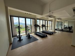 a gym with treadmills and ellipticals in a room with windows at PureJoy Hotel Langkawi in Kuah