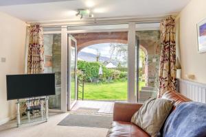 a living room with a couch and a sliding glass door at 1 Bed in Keswick oc-28382 in Braithwaite