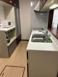 a small kitchen with a sink and a microwave at Hanako-Home in Fukuoka