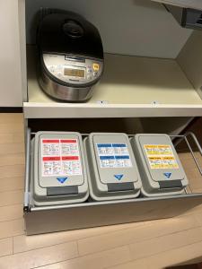 a shelf with three monitors and a printer on it at Hanako-Home in Fukuoka