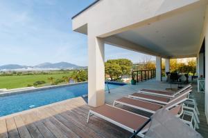 an outdoor deck with lounge chairs and a swimming pool at Stagnolo in Porticcio