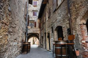 an alley in an old building with an archway at Suite Prestige Apartment in Torri del Benaco