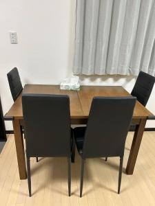 a wooden table with four chairs around it at Hanako-Home in Fukuoka