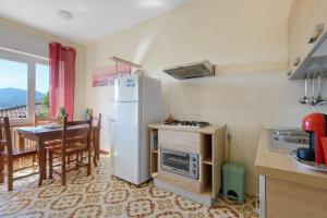 a kitchen with a white refrigerator and a table at Apartment Celeste - Isola D'elba in Portoferraio
