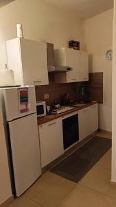 a kitchen with white cabinets and a white refrigerator at Perla di mare in La Maddalena