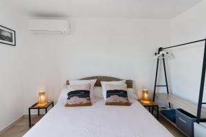a bedroom with a white bed with two lamps at Stagnolo in Porticcio +30 photos