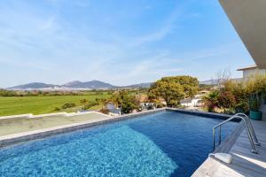 a swimming pool in the backyard of a house with mountains in the background at Stagnolo in Porticcio