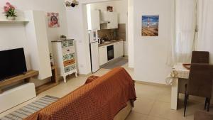 a living room with a television and a kitchen at Perla di mare in La Maddalena