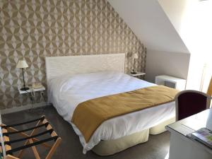 a bedroom with a large bed and a wall at Logis Hotel Restaurant La Marjolaine in Moulay