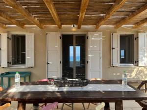 a large wooden table in a room with windows at Ellie Villa Seaside Koufonisi in Nisída Koufonísion