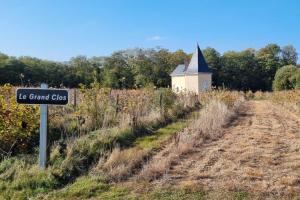 a sign next to a dirt road with a church at Le Grand Clos Marçon in Marçon