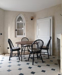 a dining room with a table and four chairs at Le Grand Clos Marçon in Marçon +10 photos