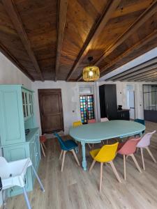 a dining room with a blue table and colorful chairs at Laroseliere in Mauléon +20 photos
