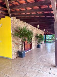 a building with two potted plants in a hallway at Quarto suíte privativo em campinas para até 3 pessoas in Campinas