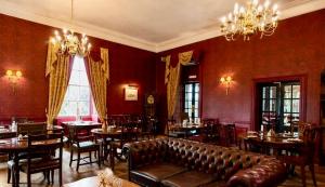 a restaurant with a leather couch and tables and chairs at The Sun Hotel in Warkworth