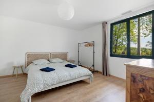 a bedroom with a bed and a large window at Gite Les 3 Tilleuls in La Ville Dieu du  Temple