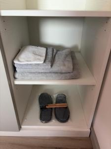 a pair of shoes and a towel in a closet at B&B Perbacco Relax in Mezzolombardo +79 photos